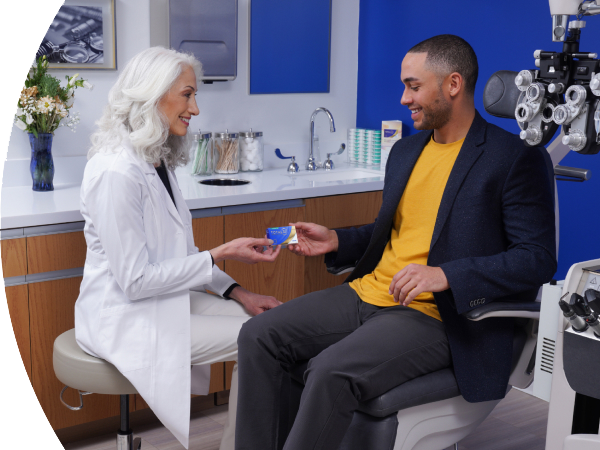 An eye care professional sharing a box of Total Contact Lenses with a patient.
