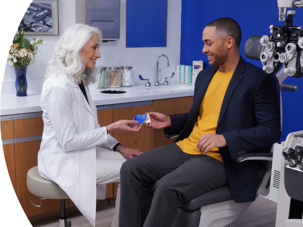 An eye care professional sharing a box of Total Contact Lenses with a patient.