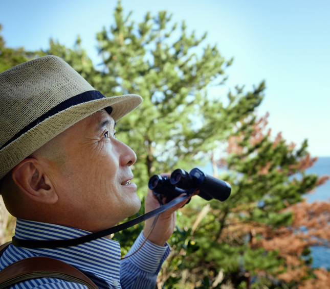 Old man looking through binoculars