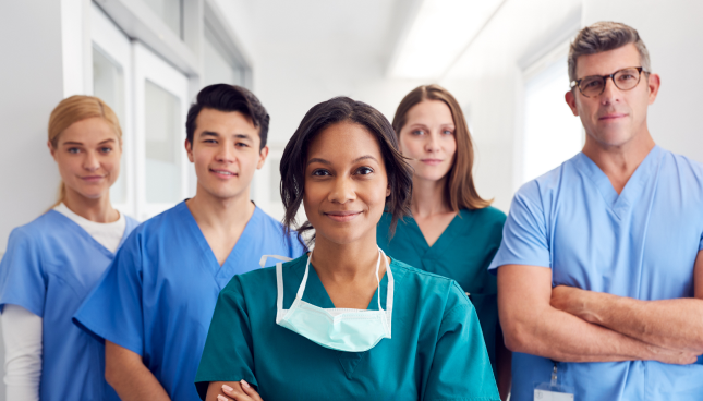 Five surgeons of various ages, ethnicities, and genders, smiling confidently at the viewer