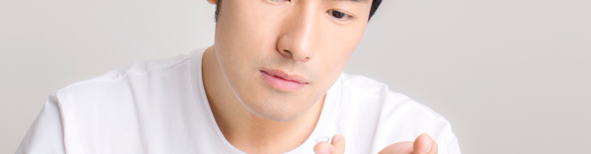 Man with contact lens on finger