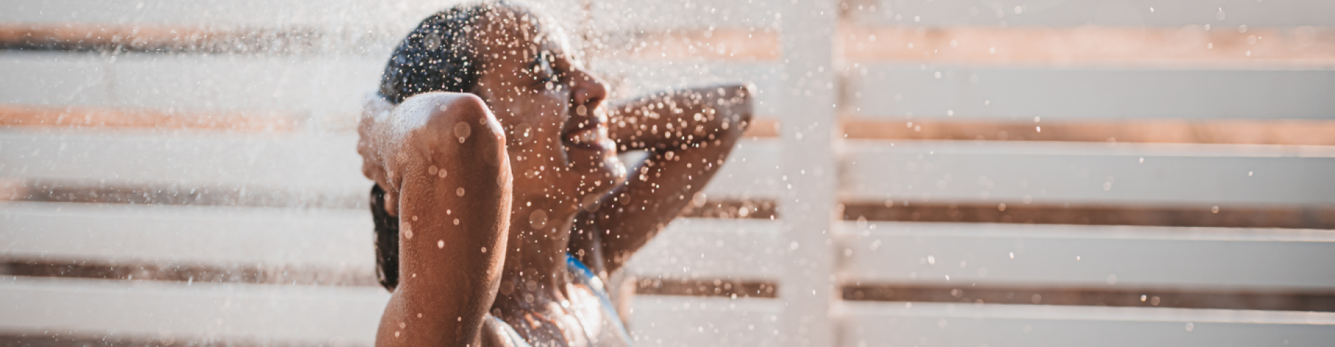 Woman in swimsuit under the shower