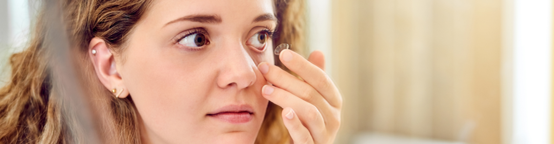Photo of a woman putting on a contact lens