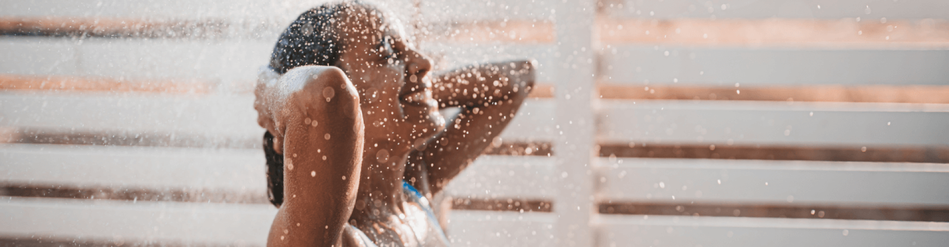 Woman in swimsuit under the shower