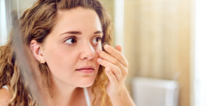 Photo of a woman putting on a contact lens