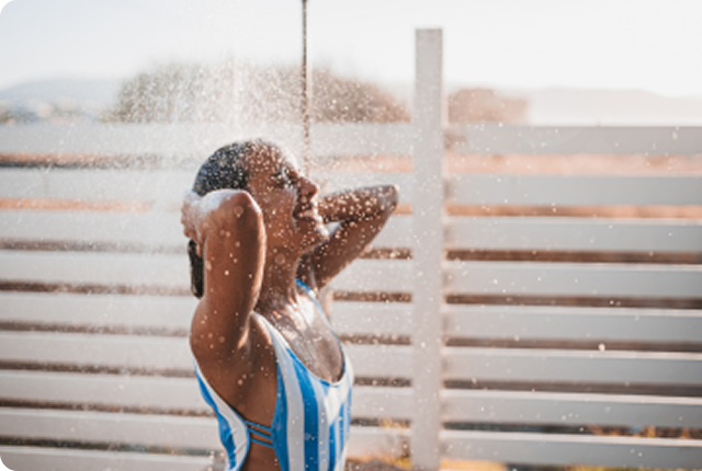 Woman in swimsuit under the shower