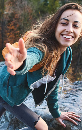 Woman smiling reaching hand  out by the river