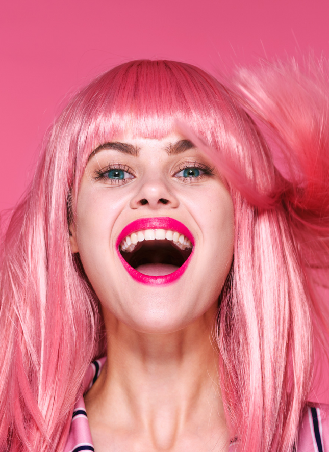 A smiling women with pink hair