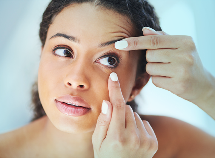 Woman applying contact lenses