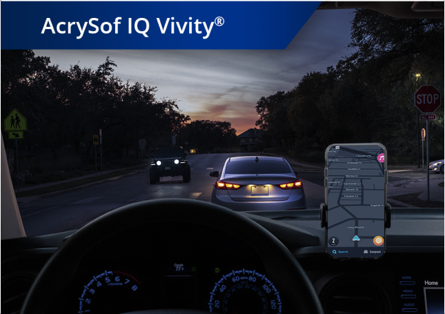 Blick aus einem Auto heraus auf eine Straße in der Dämmerung. Ein Smartphone ist auf dem Armaturenbrett befestigt. Der weiße Text links oben besagt “AcrySof IQ Vivity”.