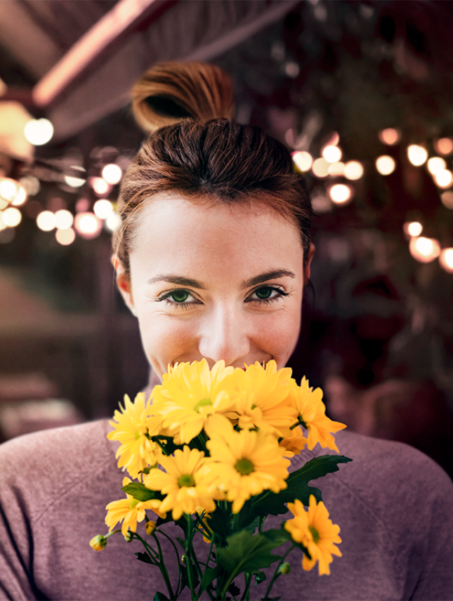 Smiling woman with yellow flower