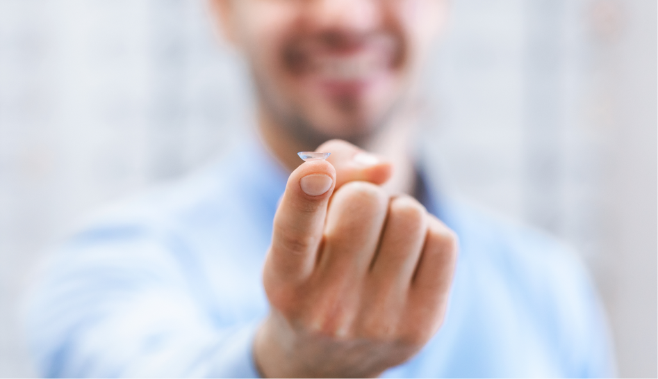 Man holding contact lens on his finger