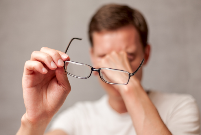 man tired holding glasses