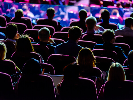 Personas sentadas en un auditorio asistiendo a una presentación o evento