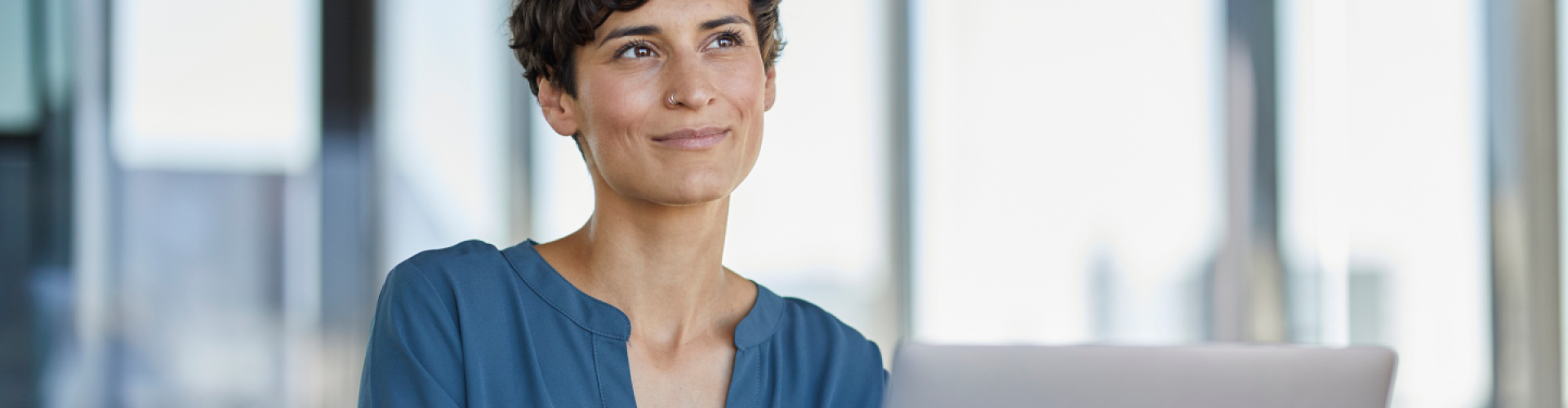 Mujer sonriente con un portátil en la oficina