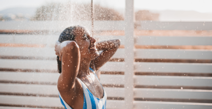 Mujer en traje de baño bajo la ducha