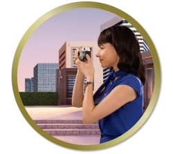 Personne tenant un appareil photo et photographiant un paysage urbain avec des immeubles modernes en arrière-plan.