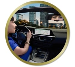 Personne au volant d’une voiture utilisant un système de navigation affiché sur l’écran du tableau de bord.
