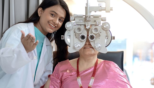 Eye care professional performing a comprehensive eye examination for a patient using a phoropter