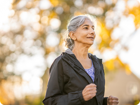 older woman jogging outdoors in a park