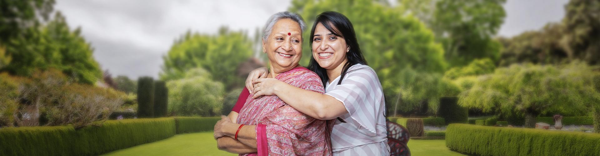 Two smiling people in the background of the garden