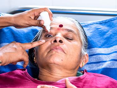 Elderly person during eye drops