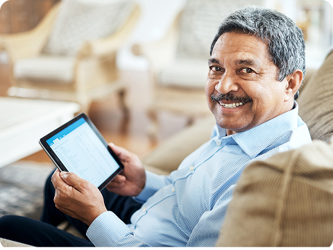 Older man using a tablet while relaxing at home