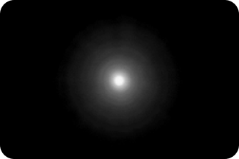 Black background with a bright light in the middle, with a halo around the light larger than the AcrySof® IQ Monofocal and AcrySof IQ Vivity® IOLs, representing the optical bench halo measurement for TECNIS Symfony Diffractive EDF IOL