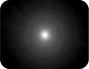 Black background with a bright light in the middle, with a halo around the light larger than the Clareon Monofocal and Clareon Vivity IOLs, representing the optical bench halo measurement for TECNIS Synergy IOL.