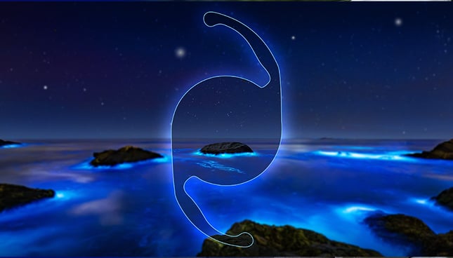 Abstract glowing blue IOL silhouette hovering over a bioluminescent ocean at night, with rocky islands, star-filled sky, and neon light reflections creating a futuristic cosmic seascape.