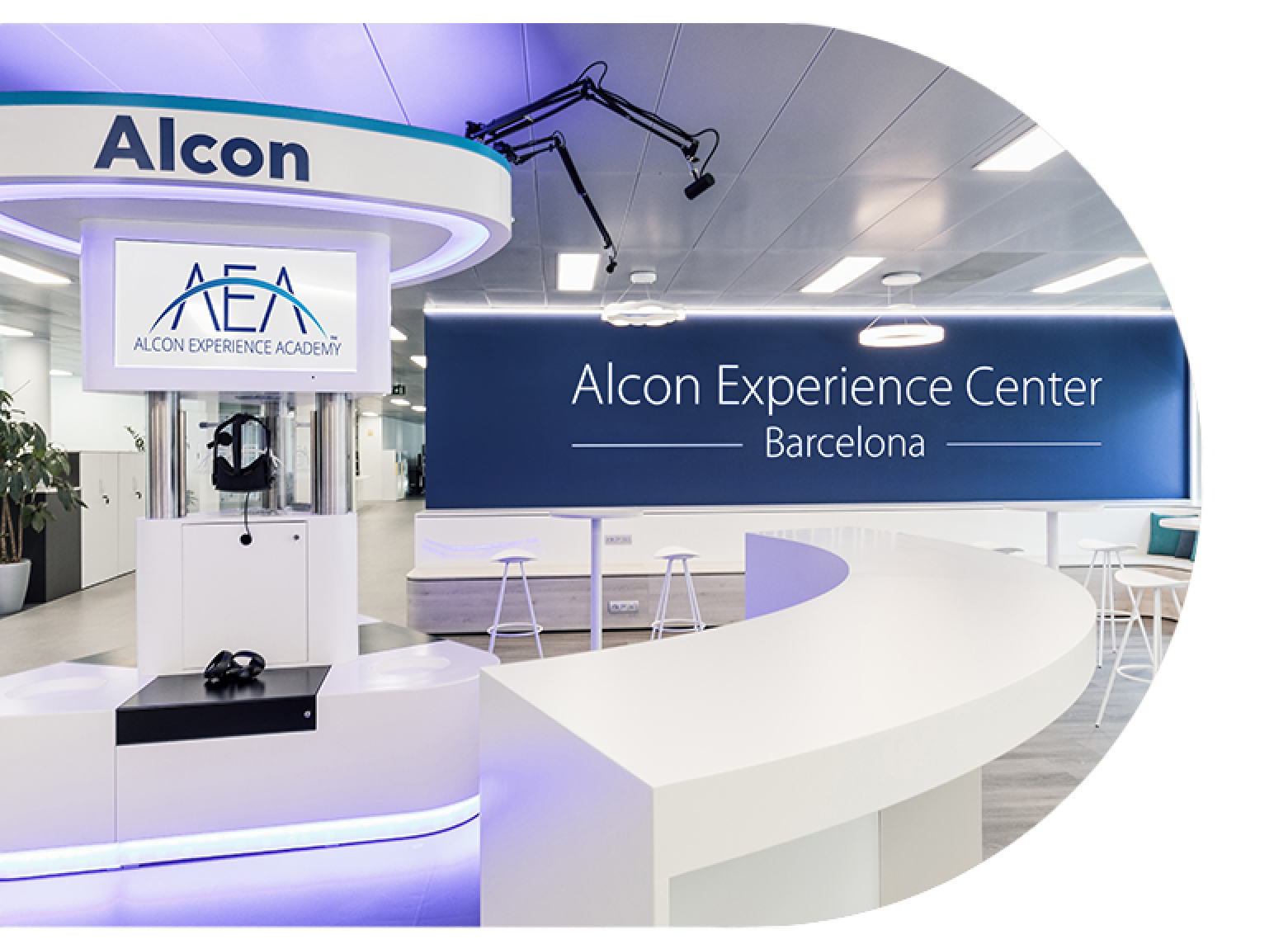 Vista interna dell’Alcon Experience Center di Barcellona, con l’insegna dell’Alcon Experience Academy, sedute moderne e attrezzature tecnologiche per la formazione.