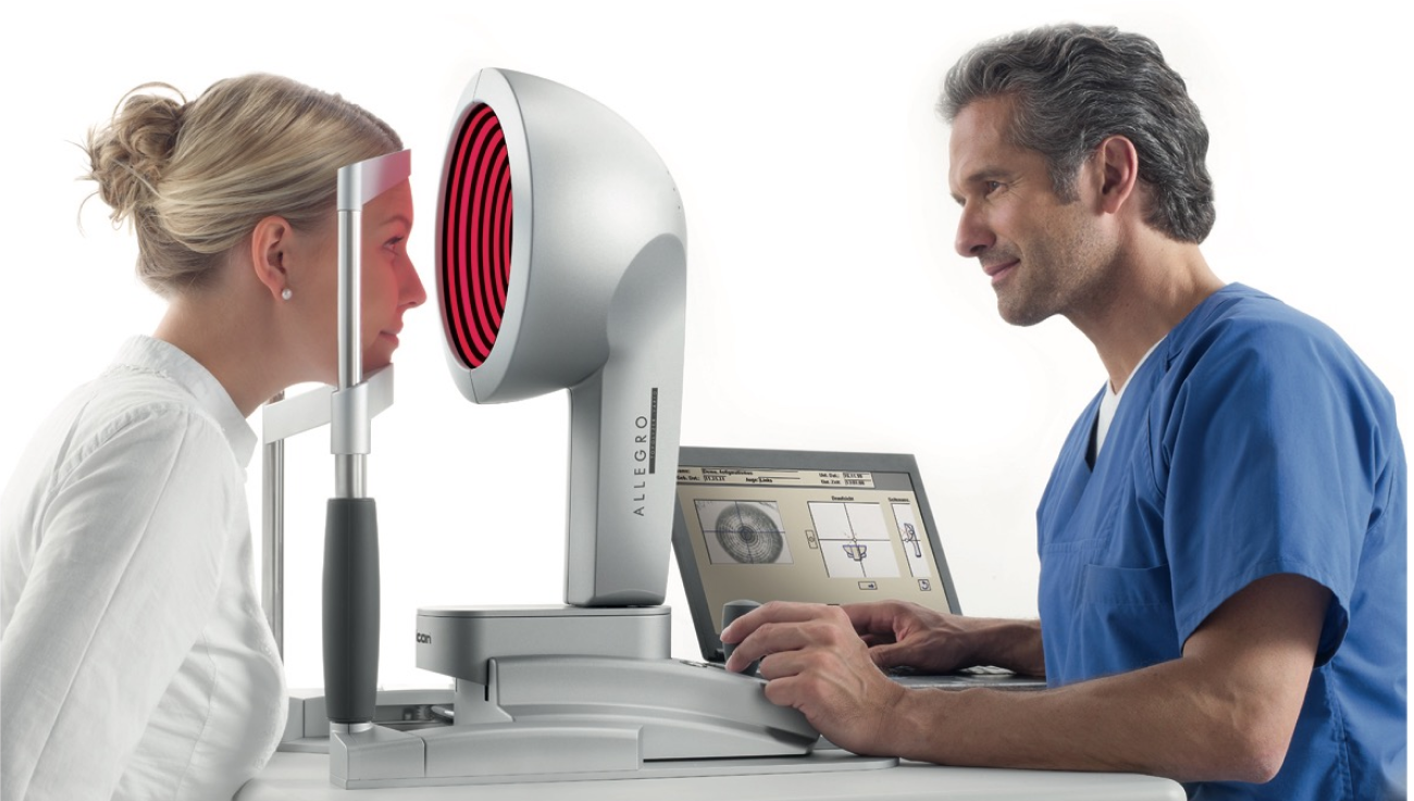 Professionista sanitario che esegue un esame oculare a una paziente utilizzando il dispositivo diagnostico Allegro con schermo di controllo.