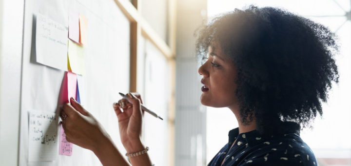 Woman writing notes on board