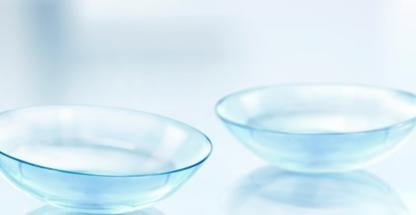 Two contact lenses on a light blue background