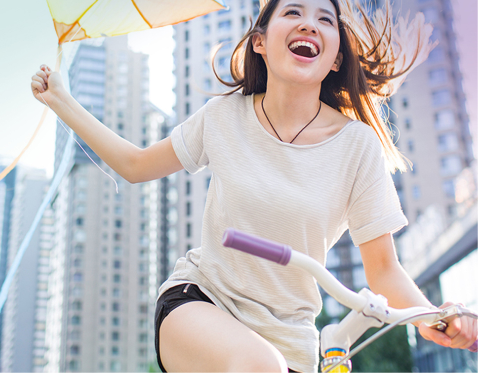 Girl holding a kite on a bike