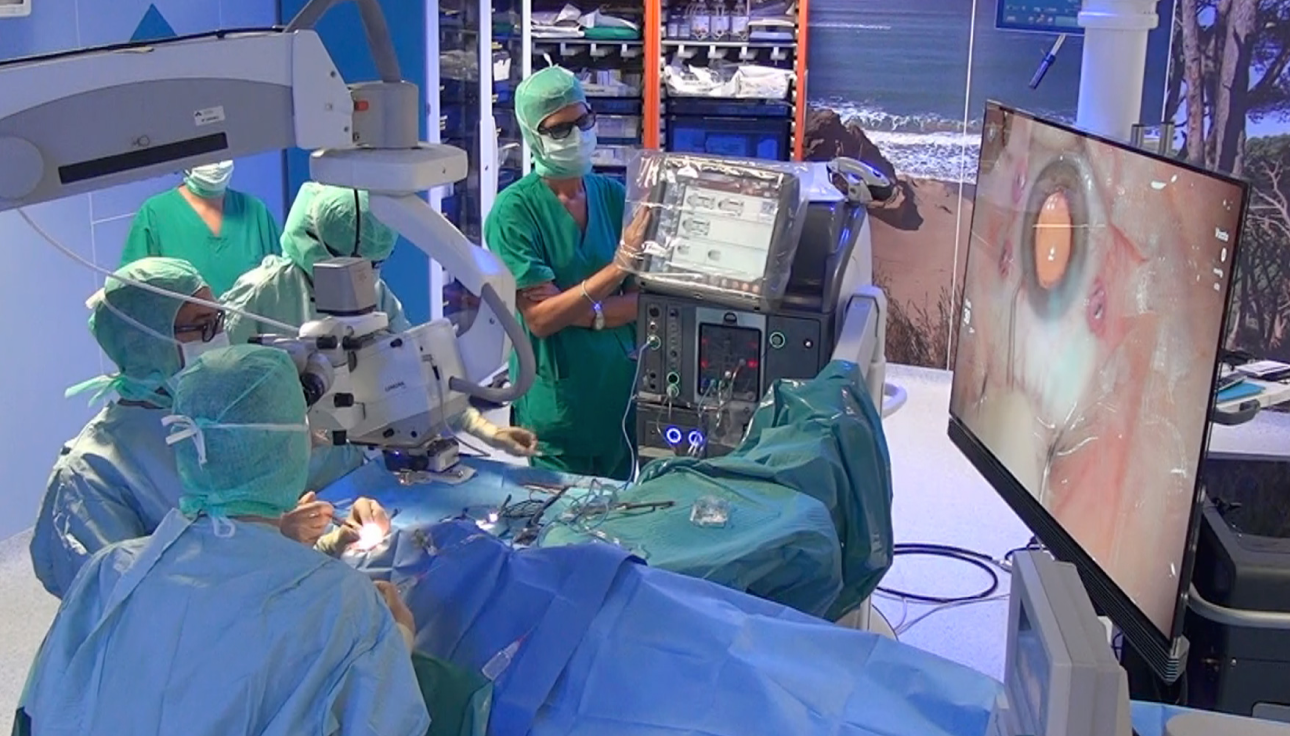 Imagen de un grupo de cirujanos en un quirófano con un paciente al que se está operando. Una pantalla NGENUITY muestra un primer plano de la cirugía a los cirujanos que están en la sala.