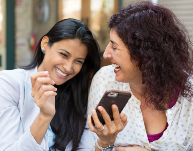 Two smiling women with a phone