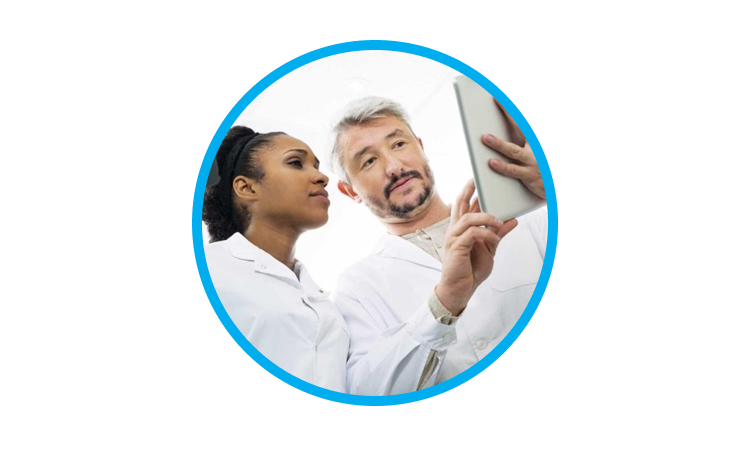 An image a man and a woman wearing a lab coat while interacting with a tablet
