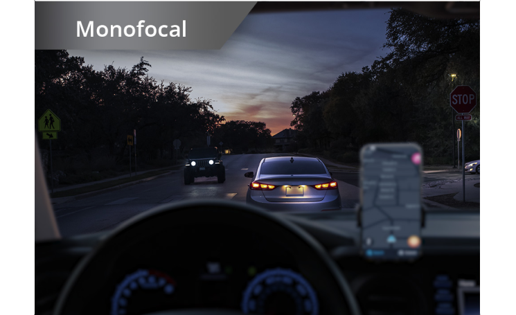 Car on the road in dim lighting with phone set up on the dashboard. White text at the top left corner of this image reads “Monofocal.”