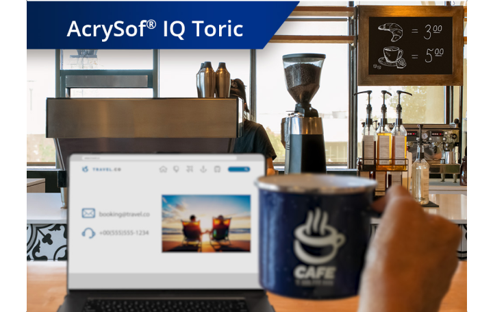 Imagem ligeiramente desfocada de uma cafetaria com vista do balcão das máquinas de café e outros produtos. Um computador portátil está aberto na bancada e a mão de uma pessoa segura uma caneca de café à direita do ecrã do portátil. O texto branco no canto superior esquerdo da imagem diz “AcrySof IQ PanOptix.”