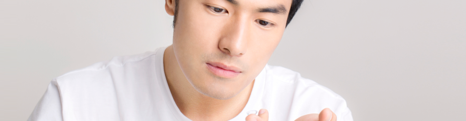 Man with contact lens on his finger