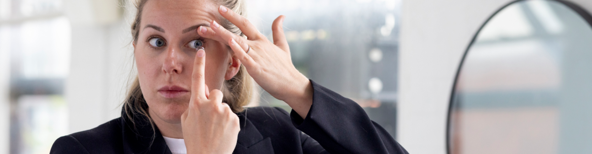 Woman putting on a contact lens