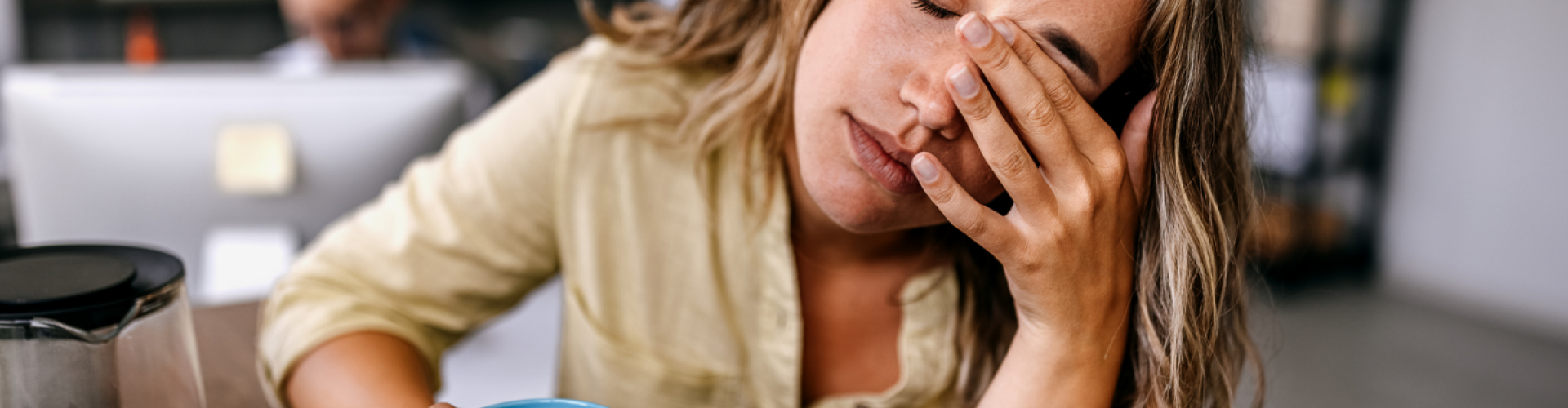 Photo of a woman supporting her head with her hand.