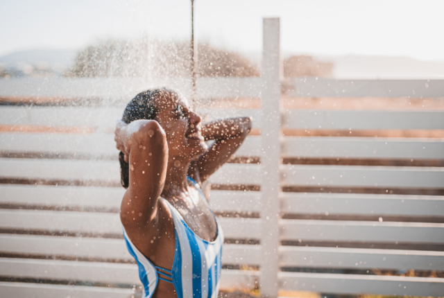 Woman in bathing suit under the shower