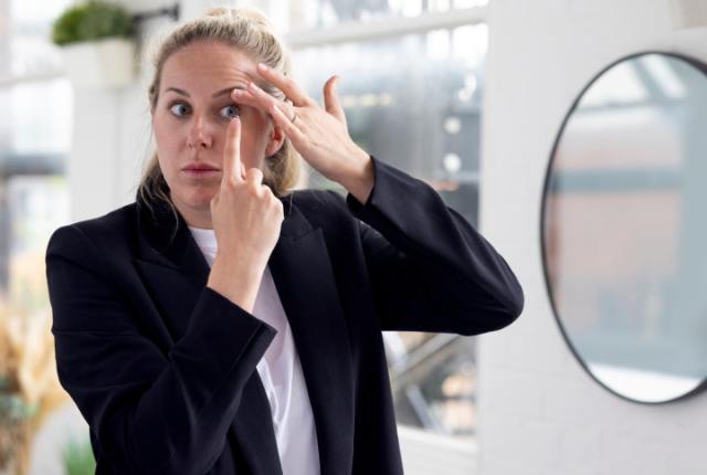 Woman putting on a contact lens