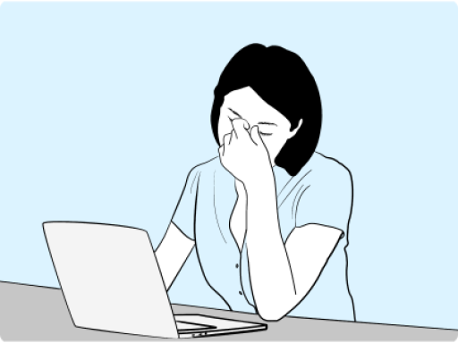 Woman at computer rubbing eyes
