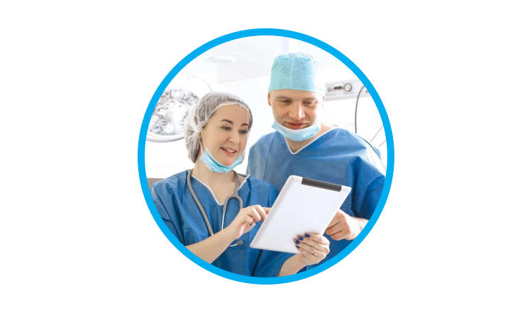 O imagine cu un bărbat și o femeie în echipament chirurgical, interacționând cu o tabletă.