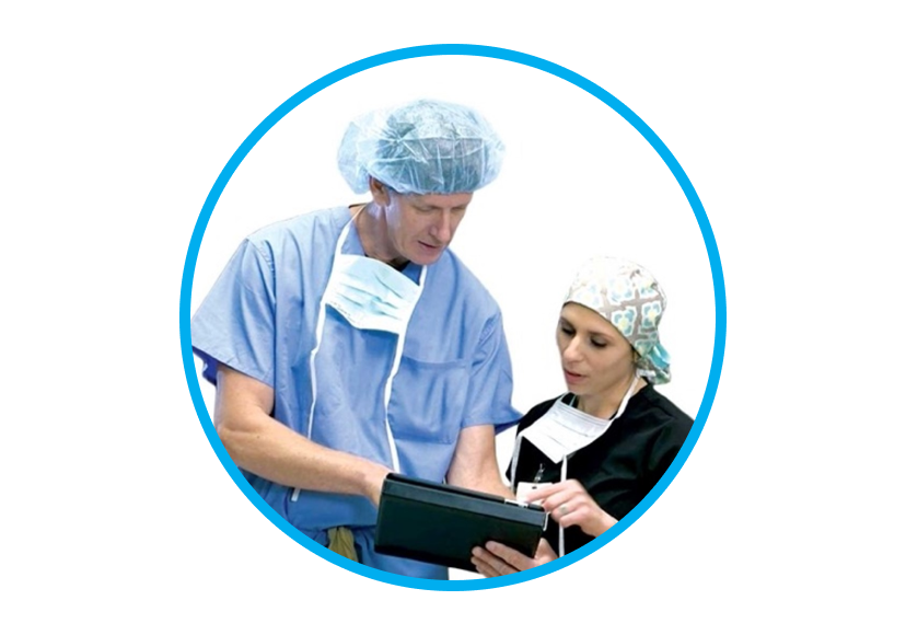 O imagine cu un bărbat și o femeie în echipament chirurgical, interacționând cu o tabletă.