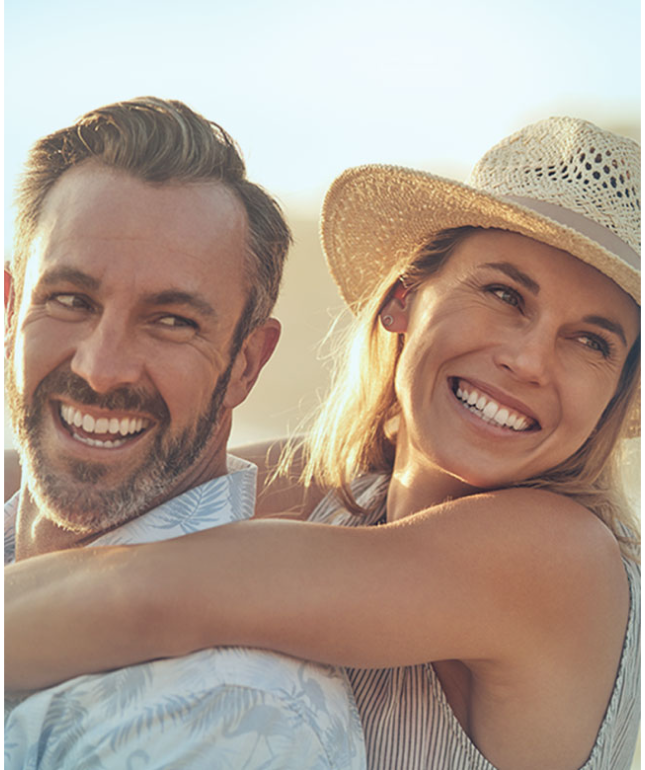 Couple embracing in sunlight while smiling