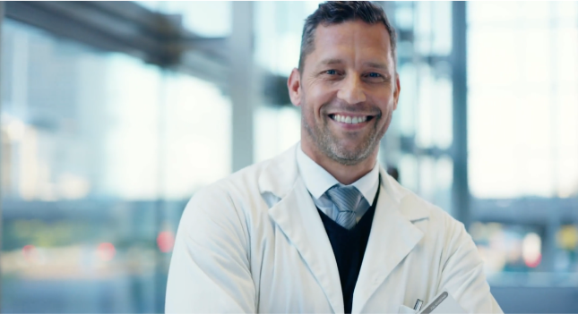 Smiling male eye doctor wearing a white lab coat